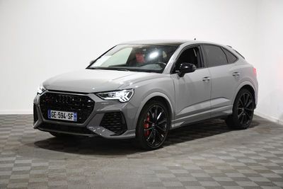un SUV Audi gris garé dans une pièce blanche au sol à carreaux