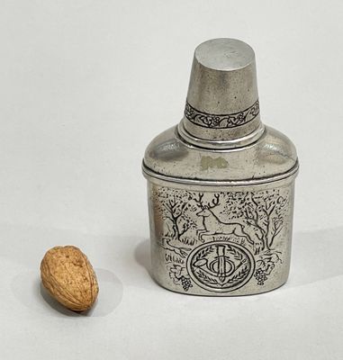 a silver container with a nut in it and a nut in the background