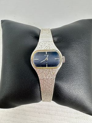a close up of a wrist watch on a pillow on a pillow