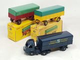 trois camions miniatures posés les uns à côté des autres sur une surface blanche