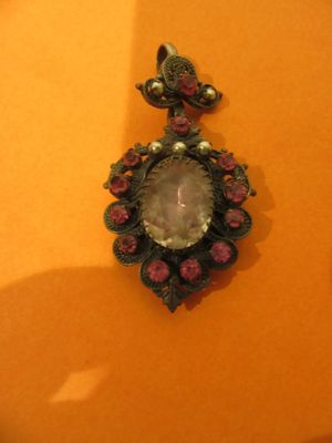 une photo d'un collier orné d'une grosse pierre au centre