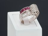 a close up of a diamond and ruby ring on a white box