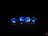 un ensemble de trois saphirs bleus posés sur une surface noire