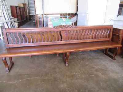 un banc en bois qui se trouve au milieu d'une pièce