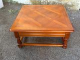a small wooden table with a wooden top on the ground