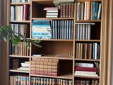 a book shelf with many books on it in a room