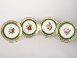 four plates with floral designs on them sitting on a white surface