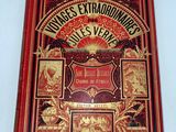 la couverture d'un livre rouge et doré sur laquelle figure l'image d'un dragon