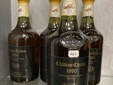 trois bouteilles de vin sont posées sur une étagère en verre