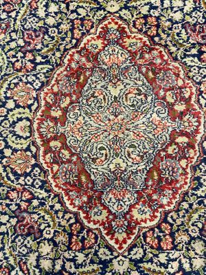 a blue and red rug with a medallion design on it