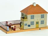 a model of a house with people standing outside of it