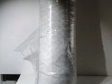 un gros rouleau de film plastique emballé dans du film plastique, posé sur un comptoir