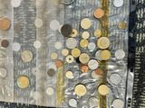 many different coins in a plastic bag on the floor