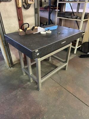 une table de travail dans un garage, sur laquelle sont posés des outils