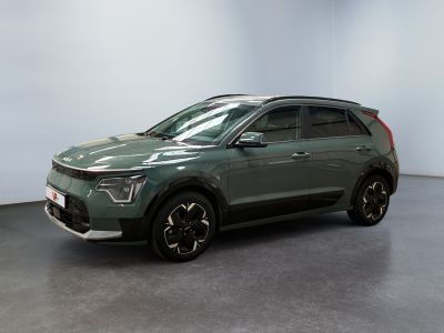 Le SUV vert est garé dans une pièce aux murs blancs.
