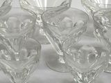 six clear glass goblets sitting on top of each other on a table