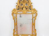 un cadre doré richement décoré, avec un miroir au centre