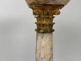 a marble vase on a pedestal with a gold base