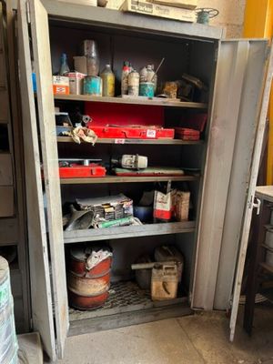 a metal cabinet with many items on it in a garage