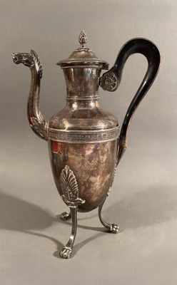 silver plated coffee pot with a black handle on a metal stand
