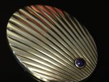 a close up of a metal object with a blue stone