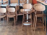 de nombreuses chaises et tables dans un restaurant, avec un mur coloré en arrière-plan