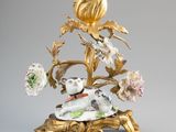 un bougeoir en or orné d'un chien et de fleurs