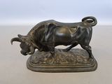 bronze statue of a bull on a base on a table