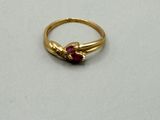 an image of a gold ring with a red stone