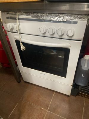 une cuisinière surmontée d'un micro-ondes, dans une cuisine