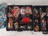 une boîte noire remplie de bijoux divers et un sac bleu