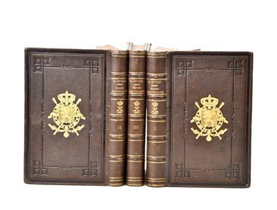 deux vieux livres ornés d'emblèmes dorés, posés l'un à côté de l'autre