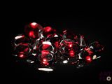 a close up of a bunch of red diamonds on a black surface