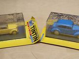 two toy cars that are in a box on a table