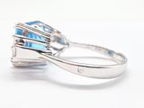 a ring with a blue stone on it on a white surface