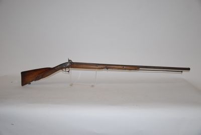 a rifle on a table with a white background