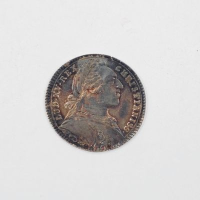 une vieille pièce de monnaie sur laquelle figure une tête de femme