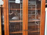une grande armoire en bois avec des portes vitrées dans un magasin
