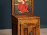 an old wooden cabinet with a painting of a woman on it