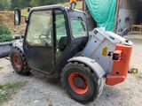a small tractor that is parked in the dirt