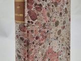 un vieux livre posé sur une table recouverte de marbre