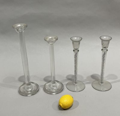 three clear glass candlesticks and a lemon on a table