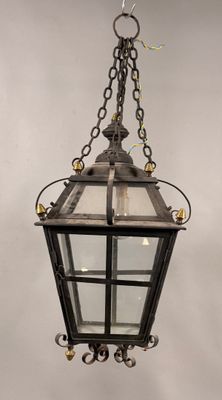 une lanterne à l'ancienne suspendue à une chaîne sur un mur blanc