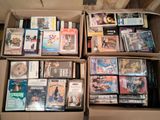 un grand nombre de dvd dans une boîte posée sur le sol