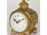 une horloge en or surmontée d'un oiseau
