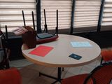 une table avec quatre chaises et un ordinateur portable posé dessus
