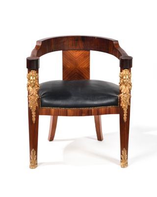 une photo d'une chaise en bois dont l'assise est recouverte de cuir noir