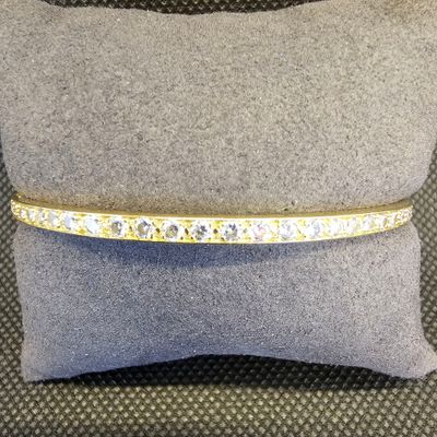 un bracelet en diamants jaunes et blancs posé sur un coussin