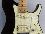 a close up of a black electric guitar on a white background