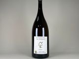 une bouteille de vin posée sur une table blanche
